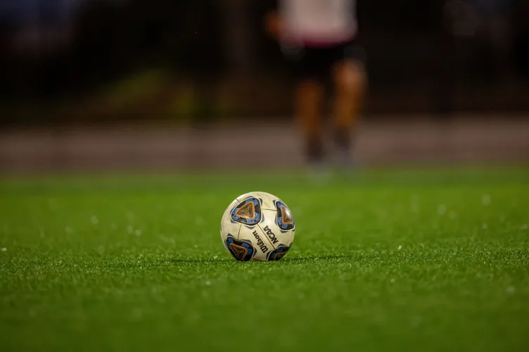 Football resting on a grass pitch